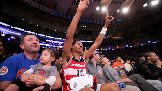 Washington Wizards guard Jordan Poole (13) reacts to a teammate's three point shot as he sits court side with fans during the third quarter against the New York Knicks at Madison Square Garden.